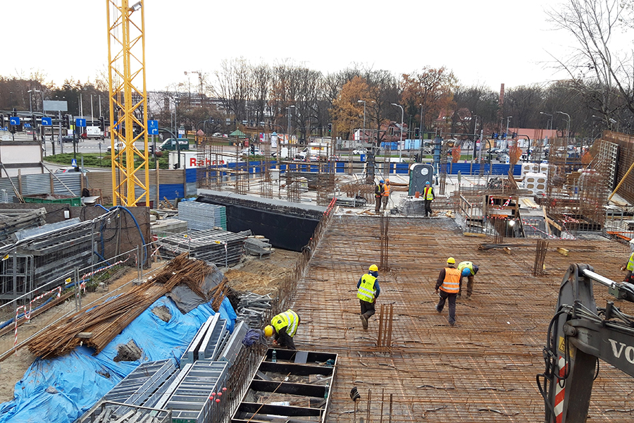 aquaberg.pl, pracownicy firmy aquaberg izolują fundament chodząc po zbrojeniach fundamentu